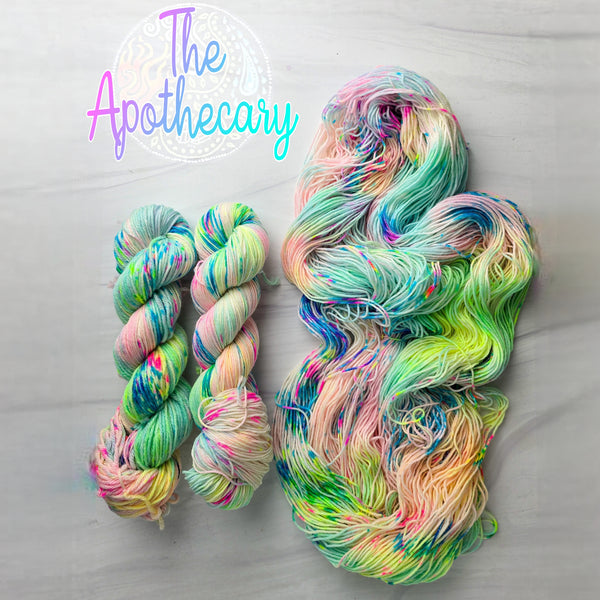 The Apothecary - Hand dyed variegated  yarn, Fingering Weight, inspired by Dungeon Crawler Carl book series - white pastel neon yellow pink blue and splashed in vibrant eon speckles