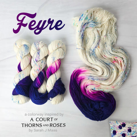 Feyre - Hand dyed Assigned Pooling yarn, Fingering Weight, speckled tonal inspired by ACOTAR by Sarah J Maas - dark midnight blue and purple pop against a white background speckled with rainbow colors