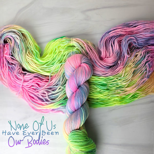 None of us have ever been our bodies - Hand dyed variegated yarn - blacklight Glowing neon rainbow  inspired by Andrea Gibson poetry