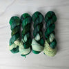 Midgard - Hand dyed Assigned Pooling yarn, Fingering Weight, speckled tonal inspired by the Crescent City series by Sarah J Maas - multiple shades of green verdant kelly moss with a pastel green white speckled color pop